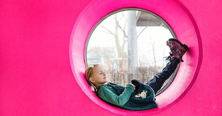 Girl laying down in a circular tub and looking out and above.